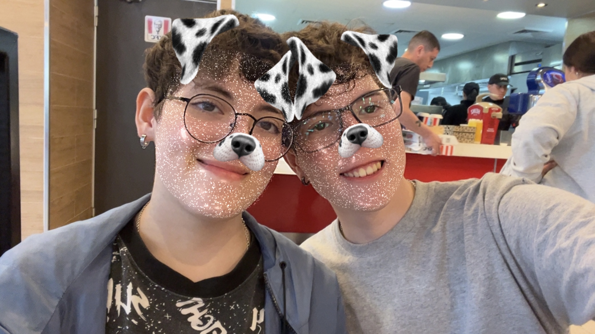 Los dos sonriendo en un local de comida con el filtro de perrito